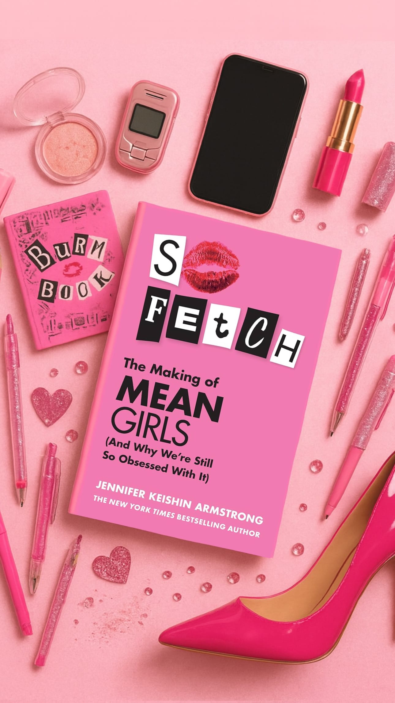 Pink-themed image with book titled "So Fetch," a flip phone, lipstick, shoe, and the "Burn Book." Glitter and pens add glam.