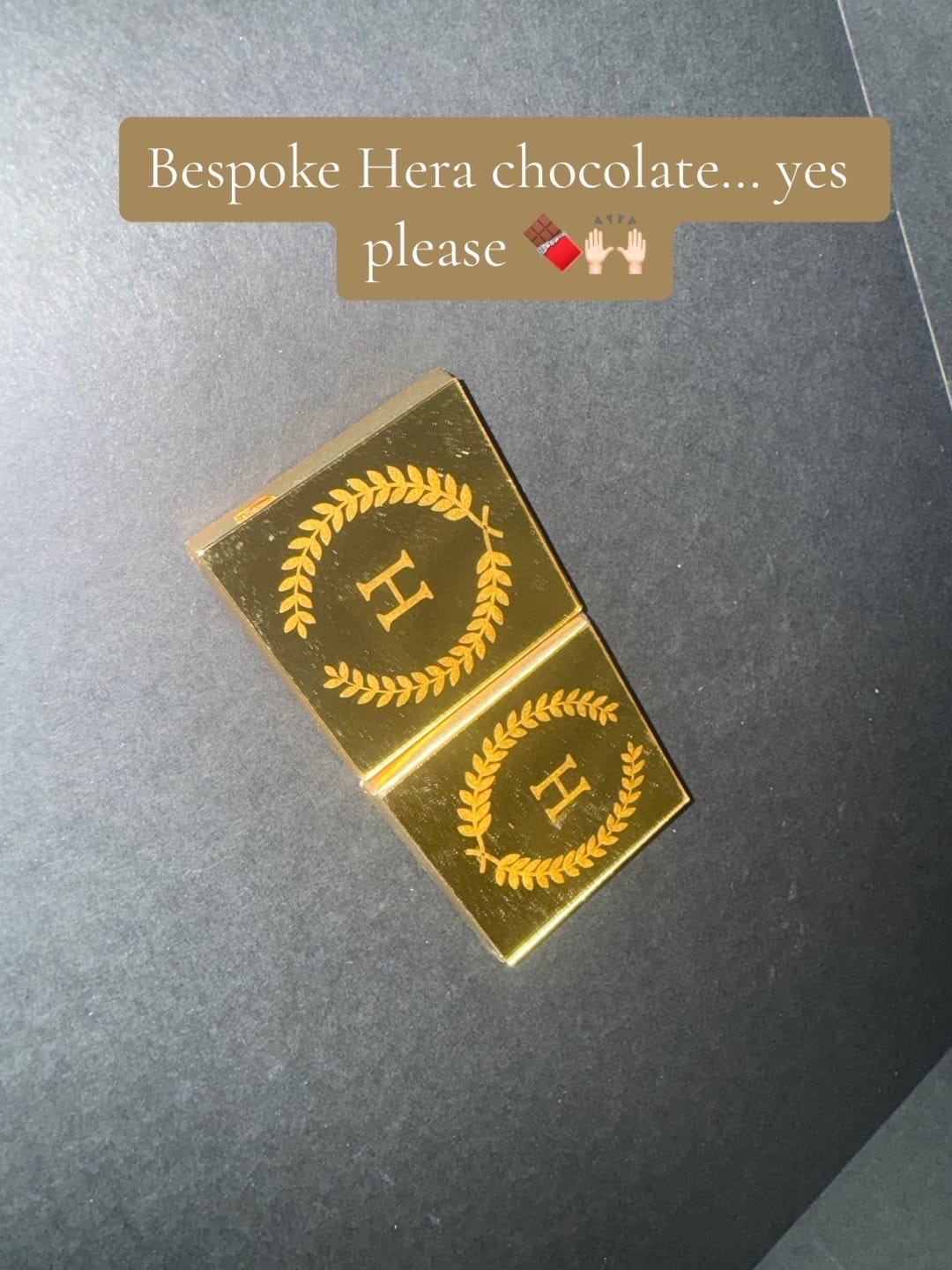 Gold-wrapped chocolates with "H" logo on dark background. Text: "Bespoke Hera chocolate... yes please" with emojis.