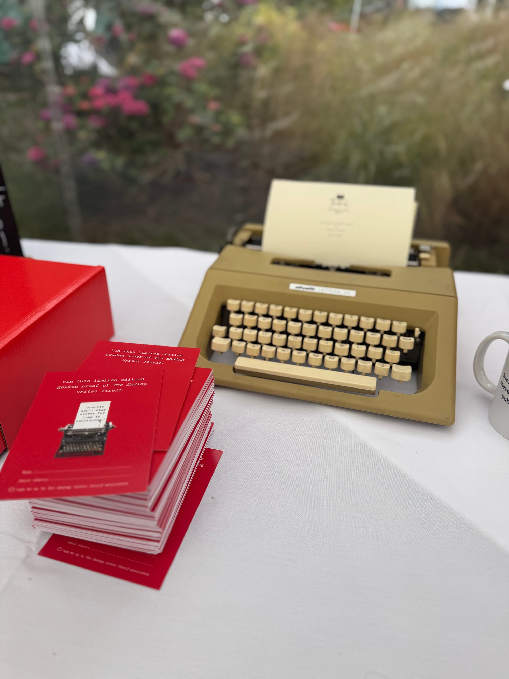 Golden typewriter next to proof copies of an unknown book. 