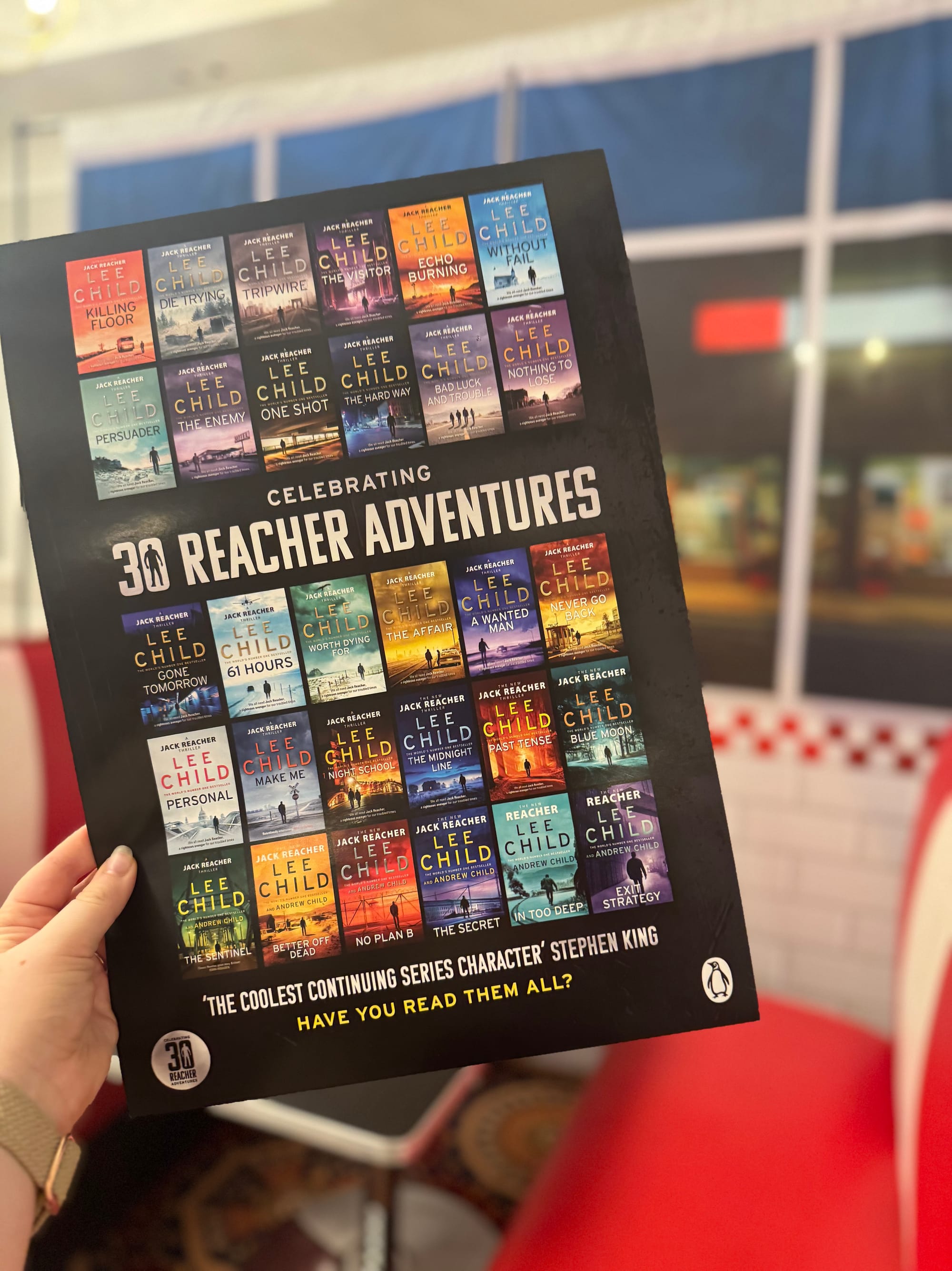 Reacher poster held up against the back drop. 