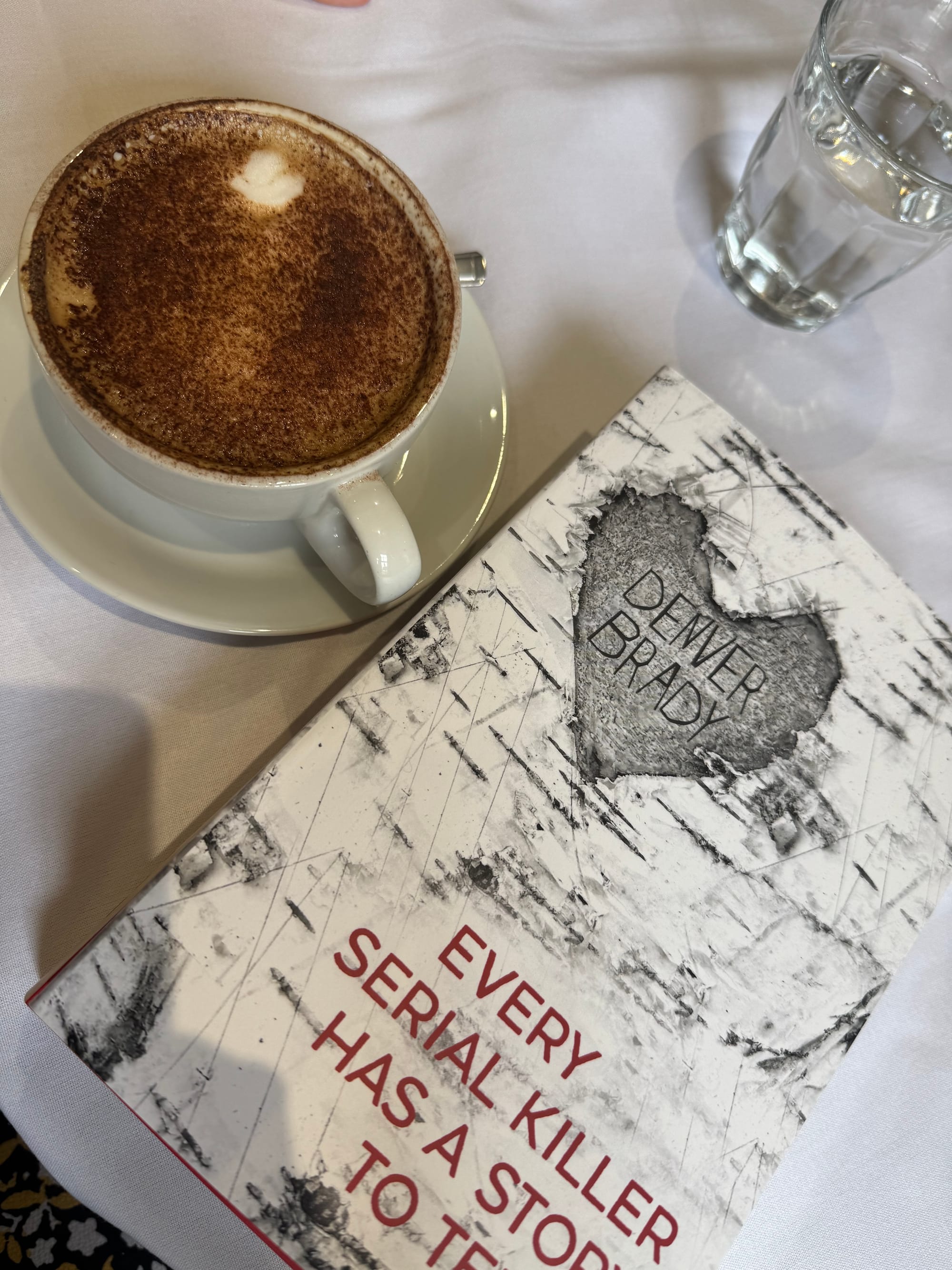 Book displayed on a table next to a cup of coffee. 