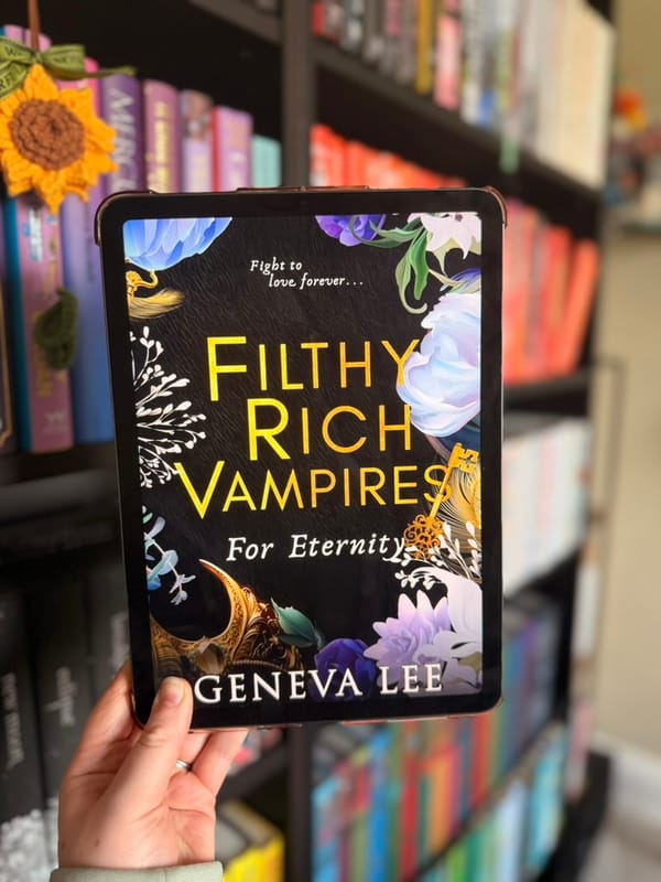 A hand holds a tablet displaying the cover of For Eternity from Geneva Lee’s Filthy Rich Vampires series. 
