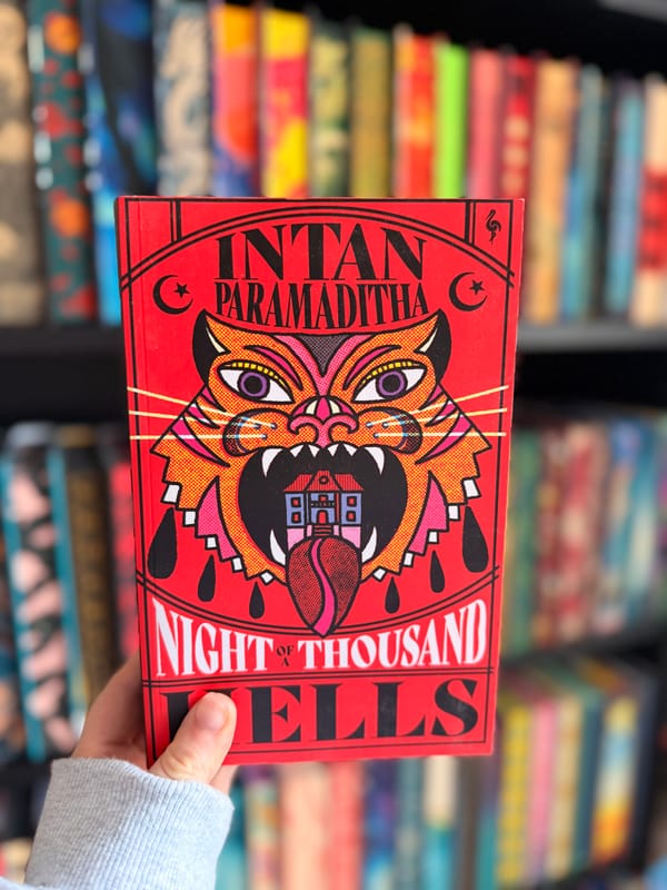 A hand holding a copy of Night of a Thousand Hells by Intan Paramaditha. 