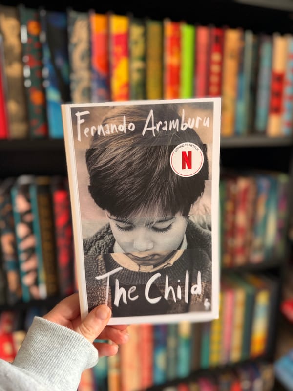 A hand holding a copy of The Child by Fernando Aramburu.